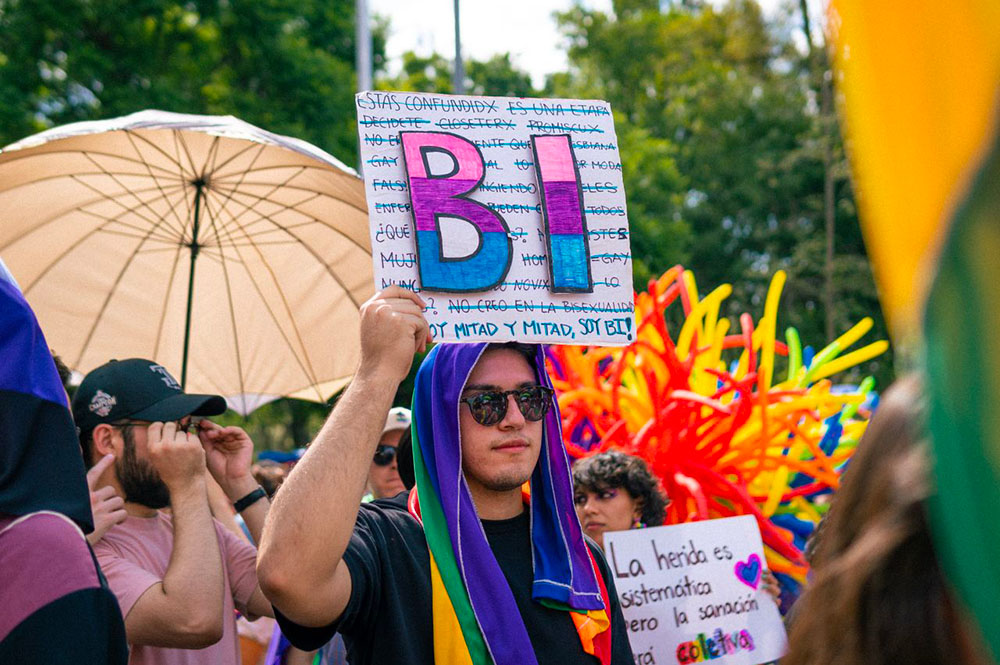 Bisexuel avec pancarte marche dans la rue