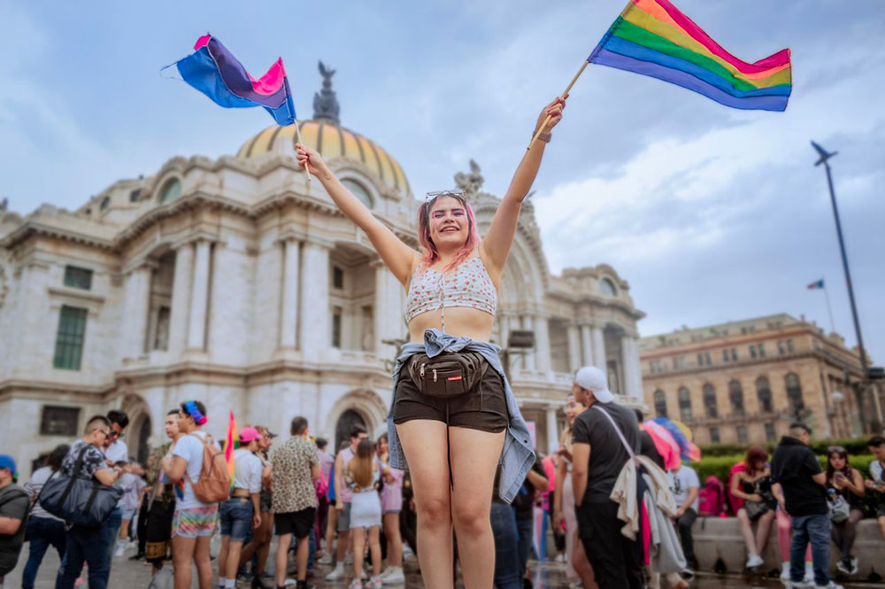 Fille avec drapeau bi et LGBT qui manifeste
